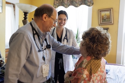 Dr. Eisenson caring for a patient in their home. 