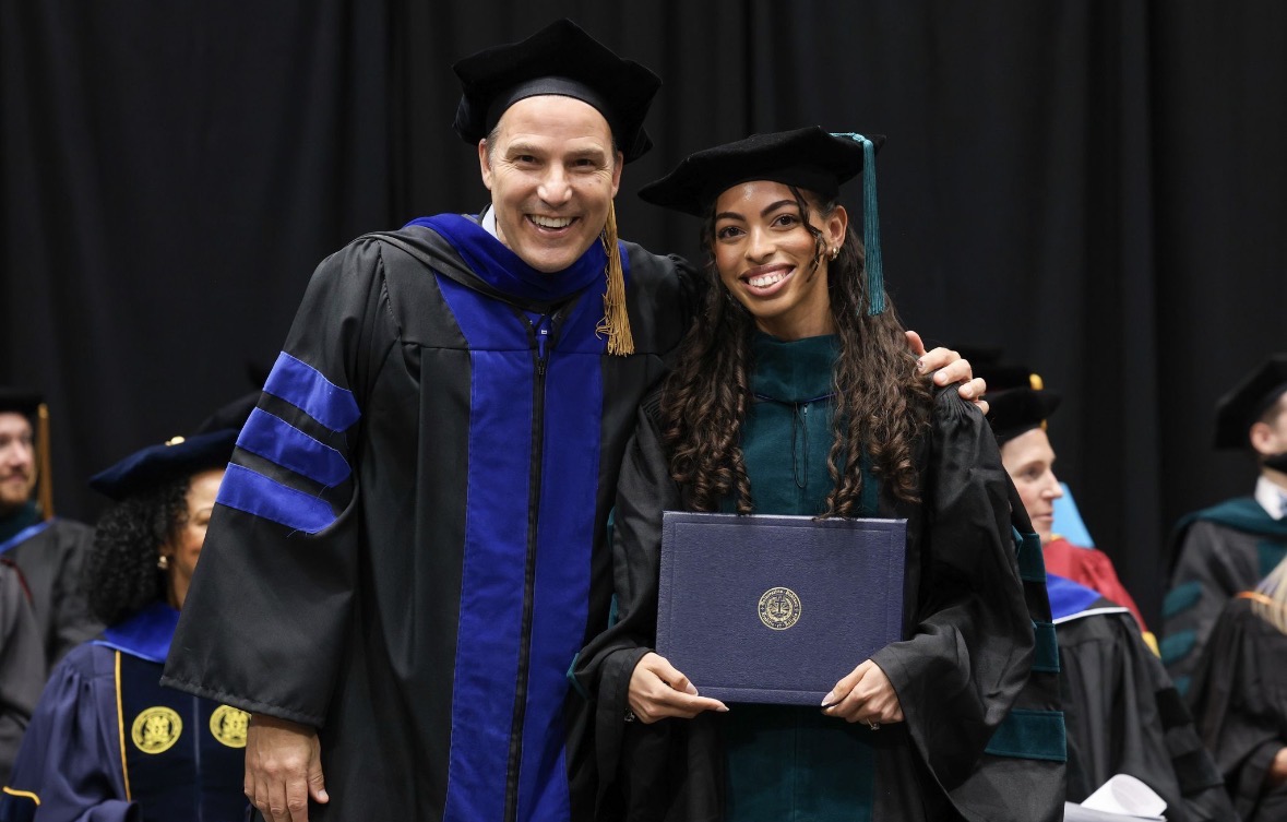 man and woman posing with diploma