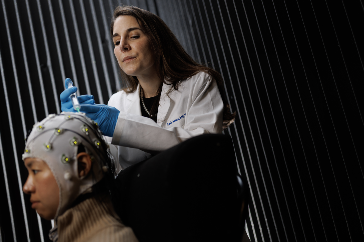Leah Acker, MD, PhD, demonstrates a procedure with postdoctoral researcher Moon Sun Kang in Acker’s lab. Acker and her team are exploring wearable technologies and other innovative approaches to help people recover more quickly after surgery and other cognitive stressors. 