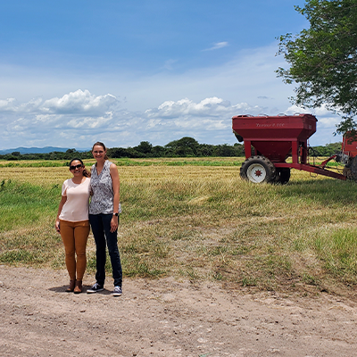 Researchers standing together in a field by farm equipment