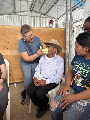 Elderly man with asthma being treated with an improvised inhaler cup.