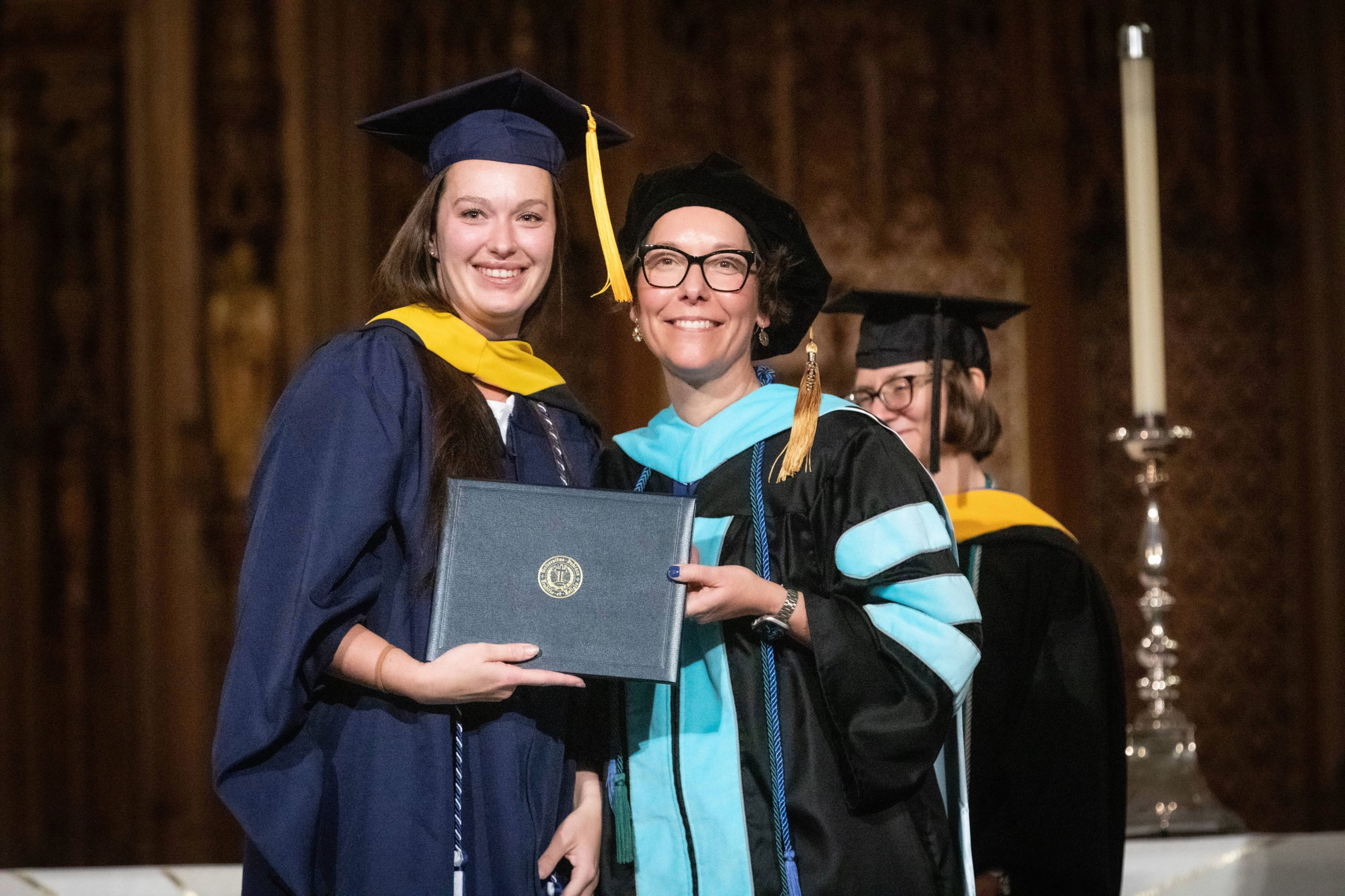 Pa student and program director smiling with diploma in hand.