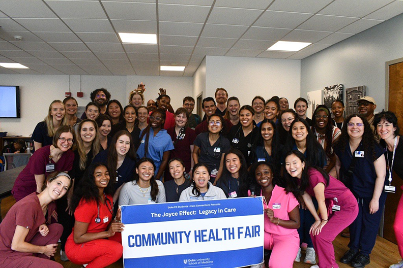 Students holding a sign that says "Community Health Fair"