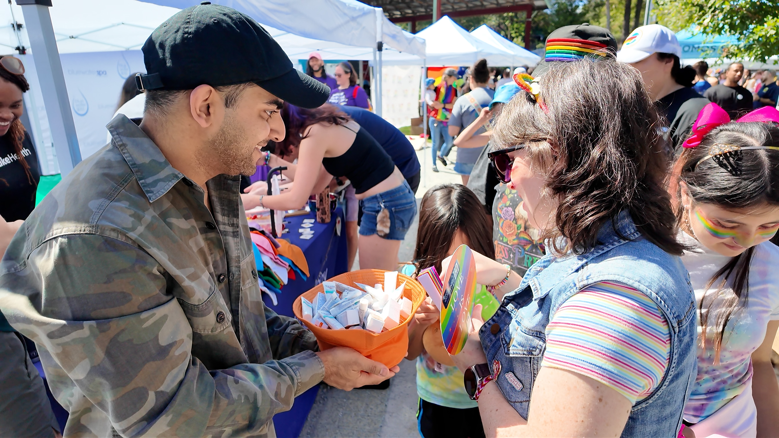 Dermatology resident hands out sunscreen at Durham Pride booth
