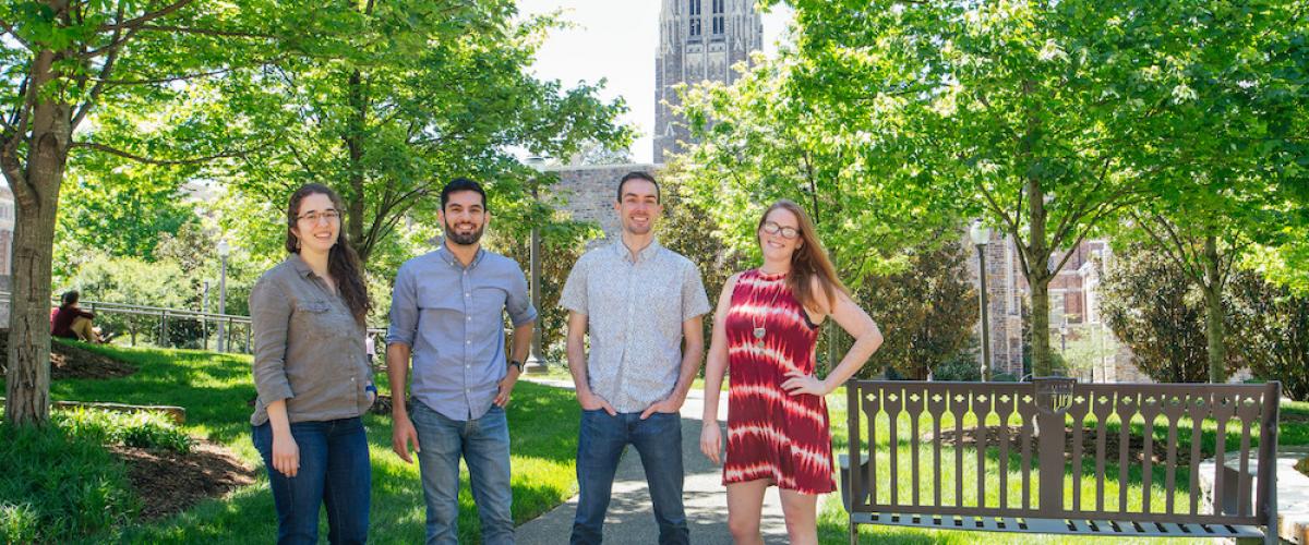 four graduate students standing outside with the Duke Chapel in the background