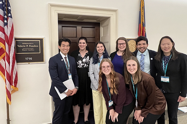 students pose for a photo by a NC representative's office door