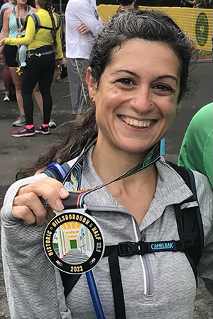 Raheleh holding a race medal