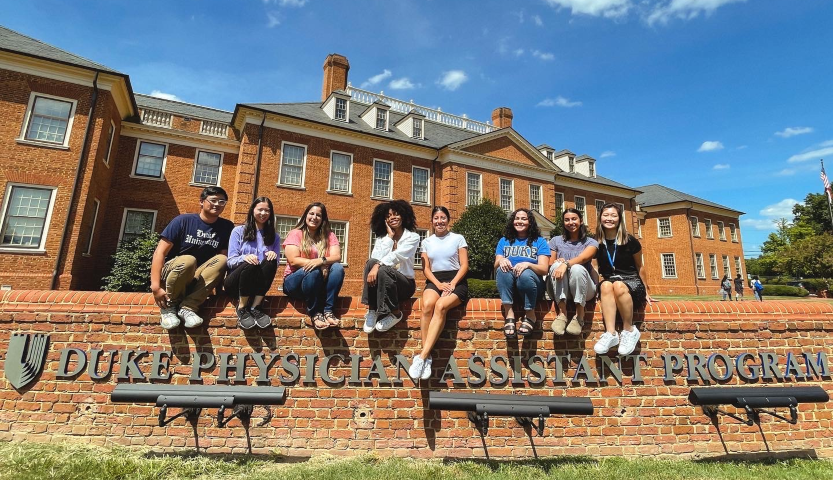 Duke PA Students sitting on wall in front of PA Program building