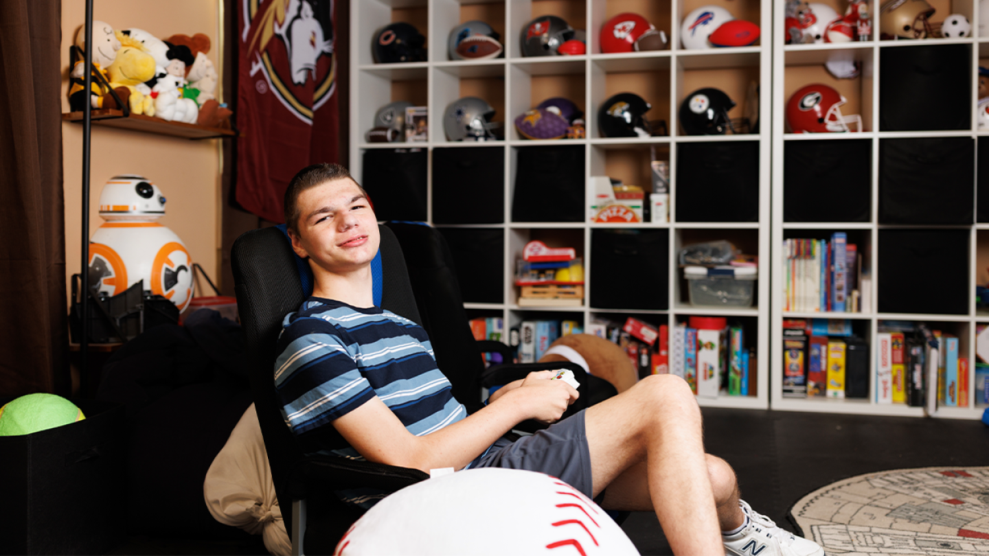 Matthew Wuchich, 18, poses for a photograph in his playroom while playing a baseball video game