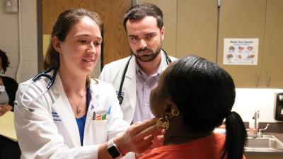 medical students examine a patient