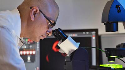 Sandeep Dave looking into a microscope