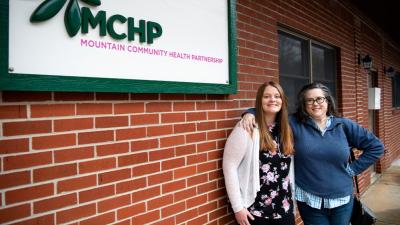 two women standing outside a health clinic