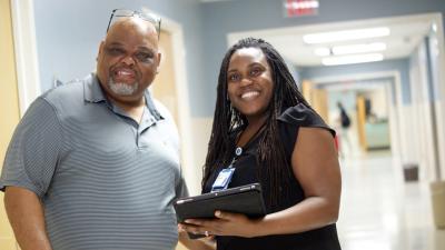 harity Oyedeji, MD, and patient standing in the clinic hallway