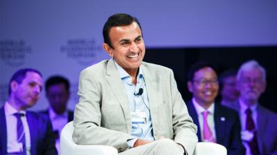 P. Murali Doraiswamy sitting in a club chair on stage at a talk