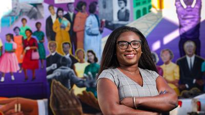 portrait of woman standing infront of mural