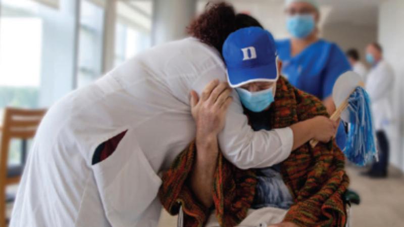 Provider hugging patient wearing a mask