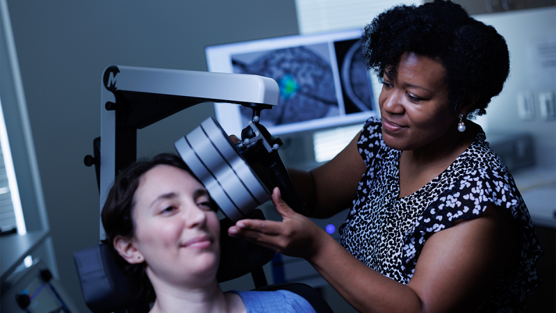 Tonisha Kearney-Ramos, PhD, demonstrating the repetitive transcranial magnetic stimulation (rTMS) procedure