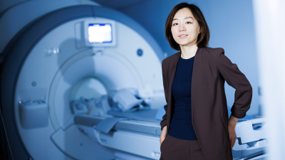 Dan Ma, PhD standing in front of an MRI machine