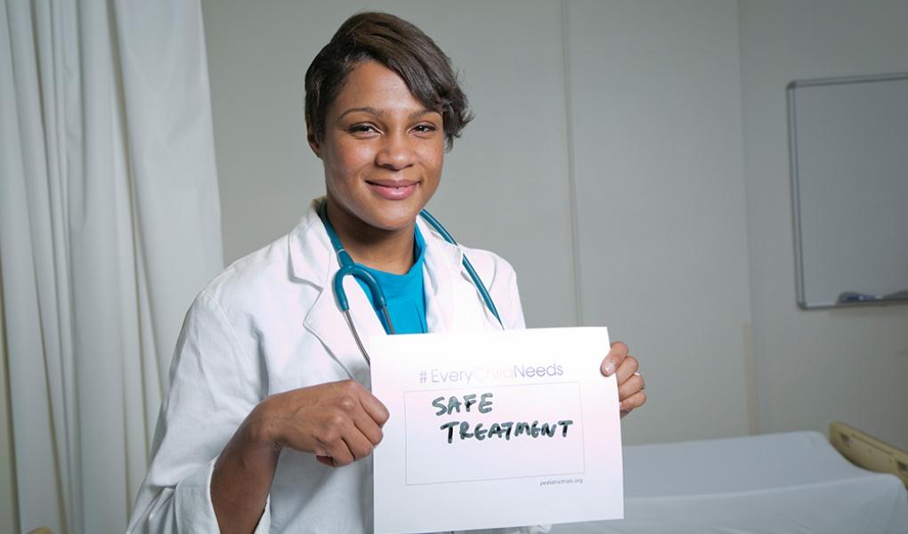 Dr. Kanecia Zimmerman holding a sign that say "Safe Treatment"