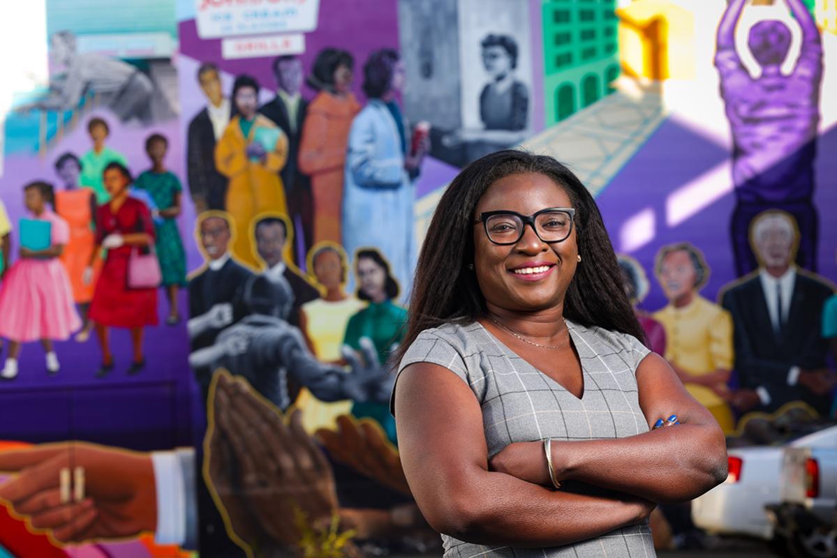 portrait of woman standing infront of mural