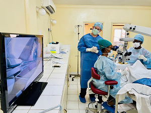 masked and gowned physicians performing eye surgery
