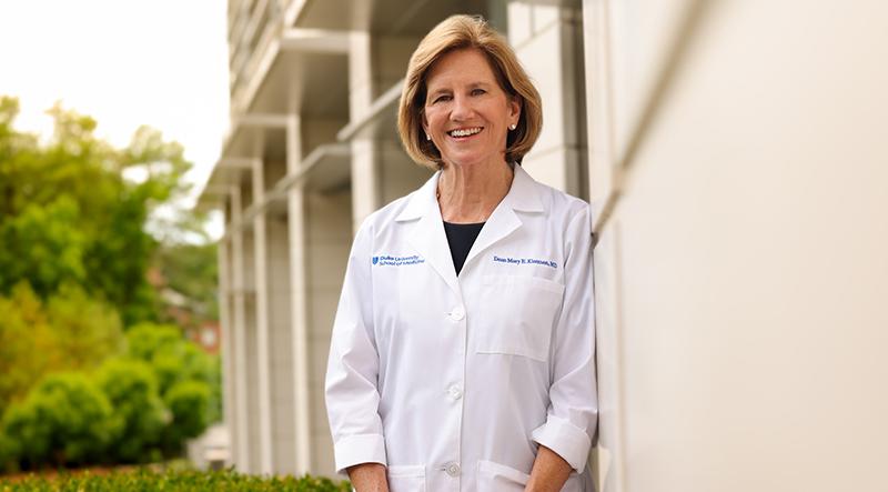 woman in white coat standing outside