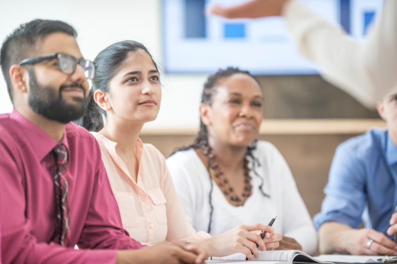 People sitting at tables looking at a speaker