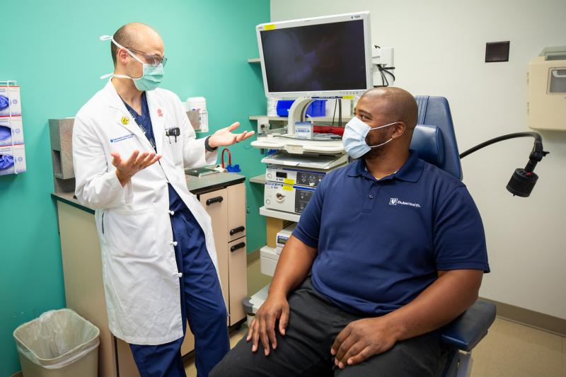 Health care professional consulting with a staff member in an Exam room.