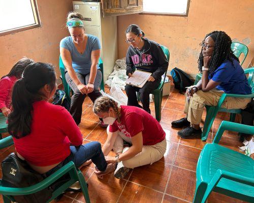 People in a circle working with a young girl. 