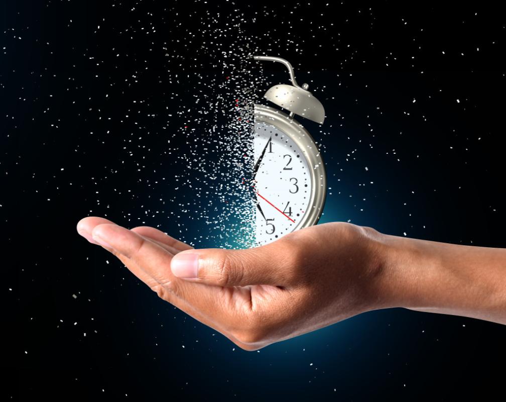 disintegrating old fashioned alarm clock held in the palm of a hand