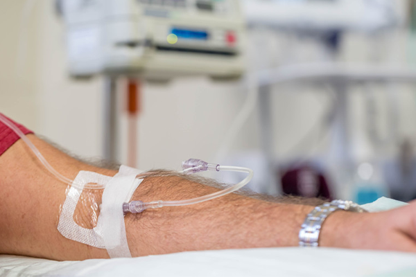 an arm with an IV inserted in it. 