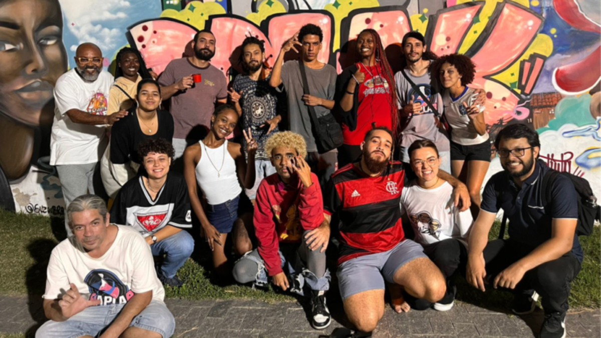 Hip-Hop Pedagogies team pose in front of mural in Brazil 