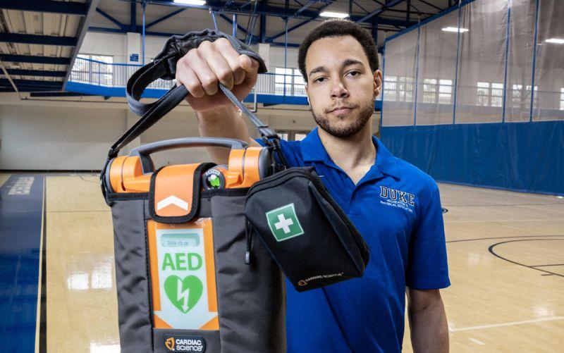 Ty Johnson holds an AED at Wilson Recreation Center. He was one of two staff members who brought an AED to the court during a medical emergency. Photo by Travis Stanley