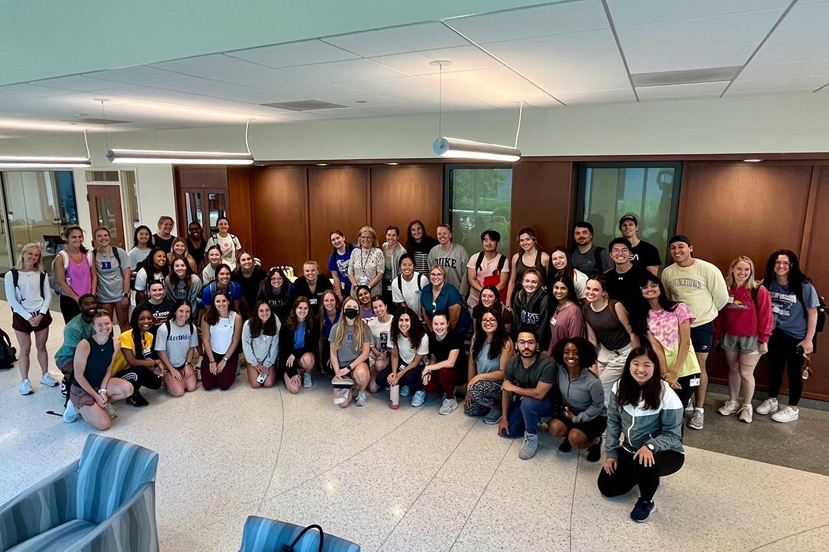 dozens of Duke DPT students gathered for a group photo with Dr. Laura Case