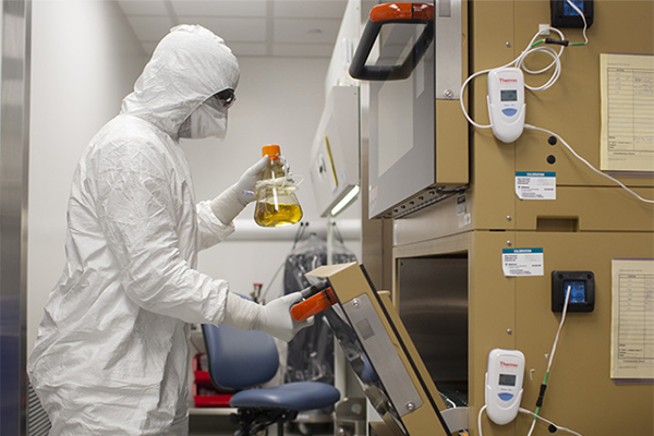 A person wearing protective equipment working in a lab.