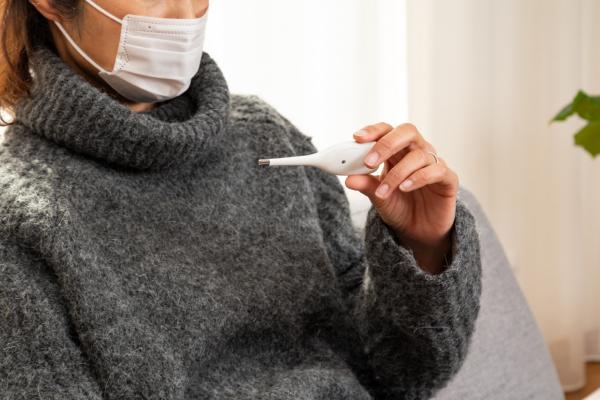 Stock photo of woman holding thermometer