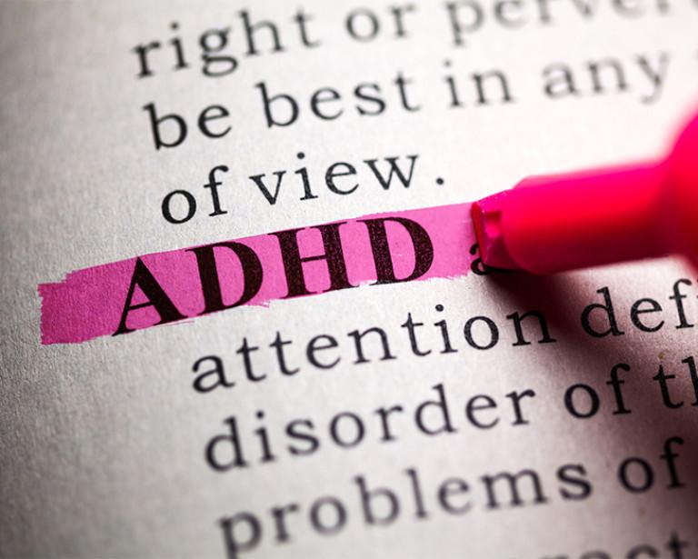 A pink highlighter highlights the word ADHD in a page of text.