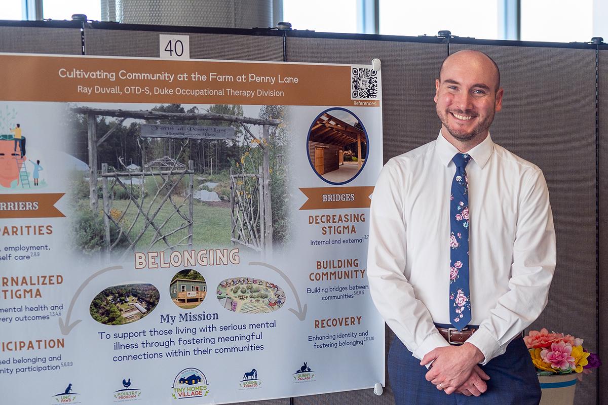 ray next to his poster he's presenting at a spring 2024 event on Duke's campus