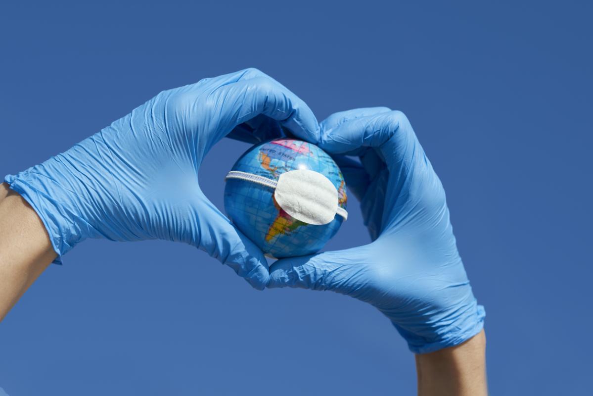 Photo: Two gloved hands holding an earth model