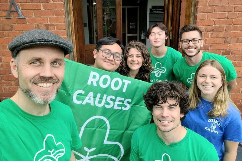 A group of students with a root causes banner.