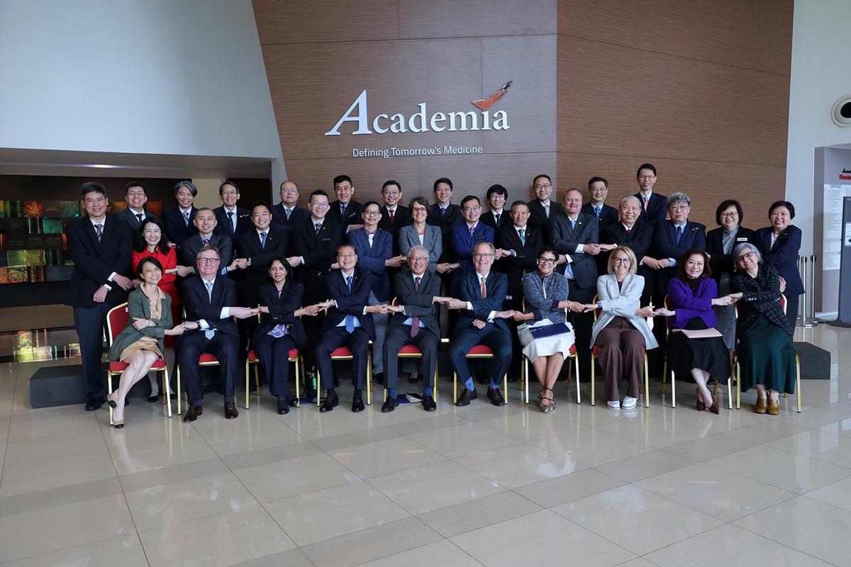 Image: A group of professionally dressed individuals in suits and ties posing together for a formal photograph.