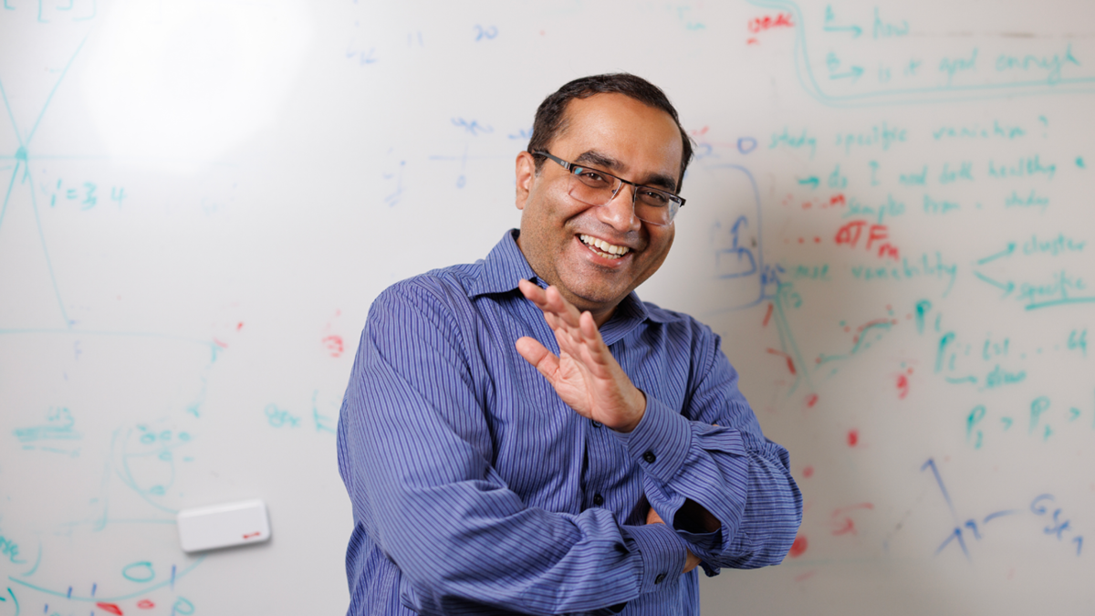 Rohit Singh, PhD, laughing in front of a whiteboard