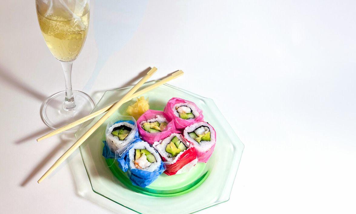 Image of sushi, wine, and chopsticks