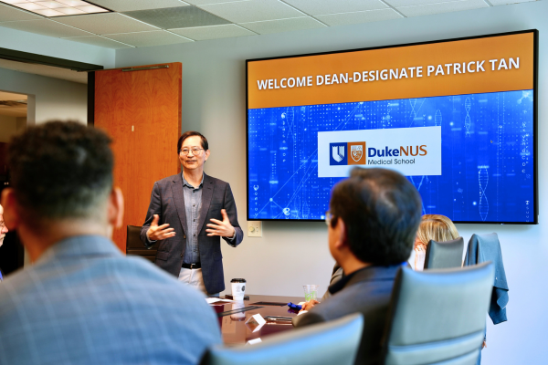 Image: Duke-NUS Dean-designate Patrick Tan speaks in front of a large screen, illustrating key points for the audience's understanding.