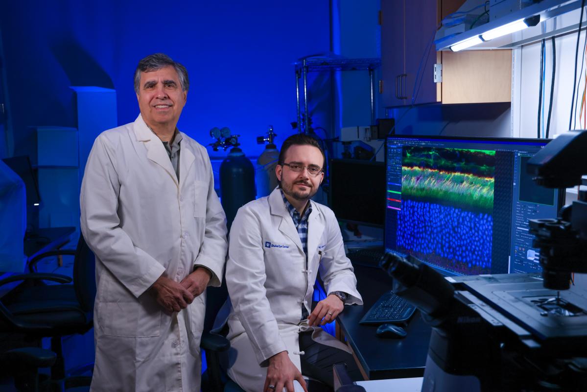 Eye doctors in a laboratory sitting in front of a computer