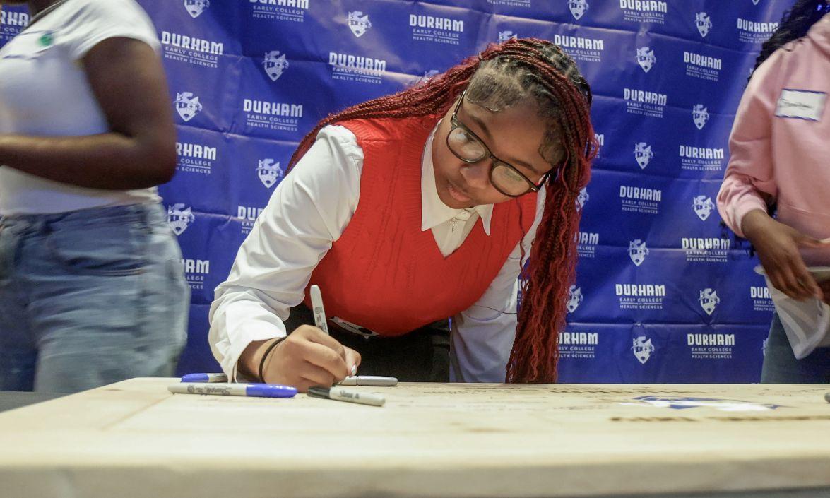 Autumn Reynolds signs her commitment to attend the Durham Early College of Health Sciences during a signing ceremony at Duke University Hospital on April 20, 2026.