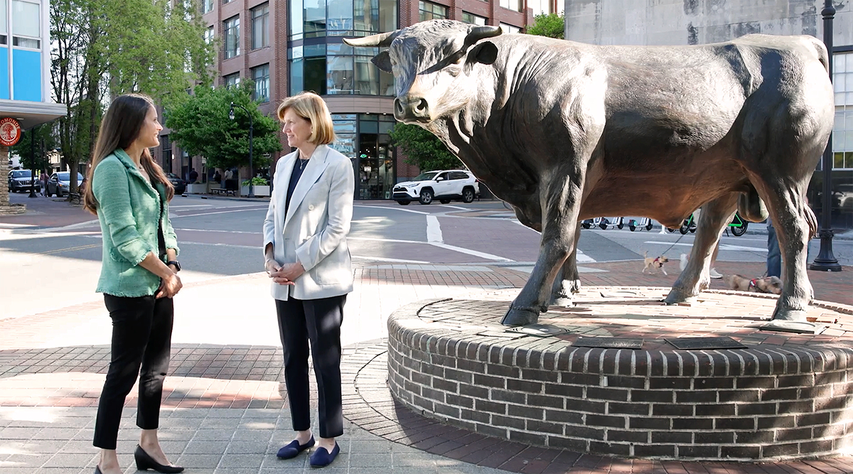 Dean Mary Klotman & Dr. Susanna Naggie, downtown standing next to the Durham Bull sculpture.
