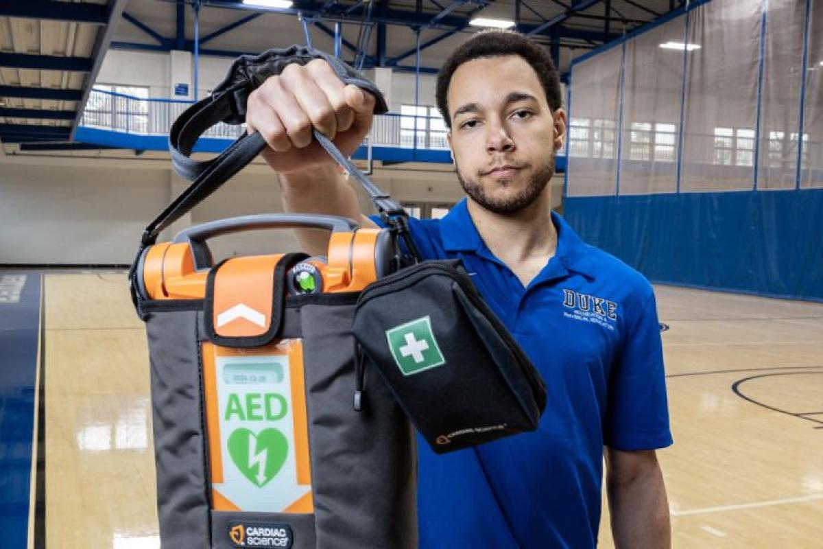 Ty Johnson holds an AED at Wilson Recreation Center. He was one of two staff members who brought an AED to the court during a medical emergency. Photo by Travis Stanley