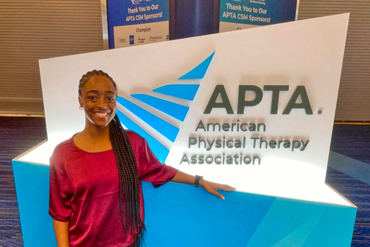 Cierra posing by an APTA sign