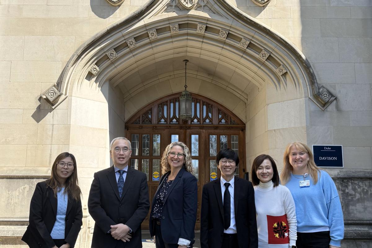Group of six people standing in front of a building entrance